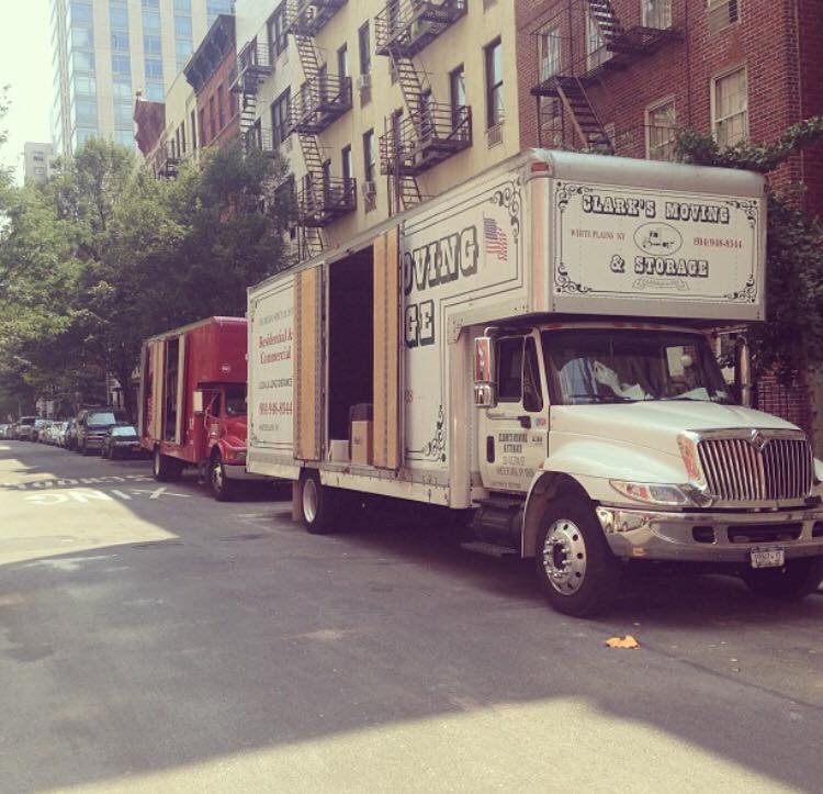 Clark's Moving and Logistics truck loading on a city street.