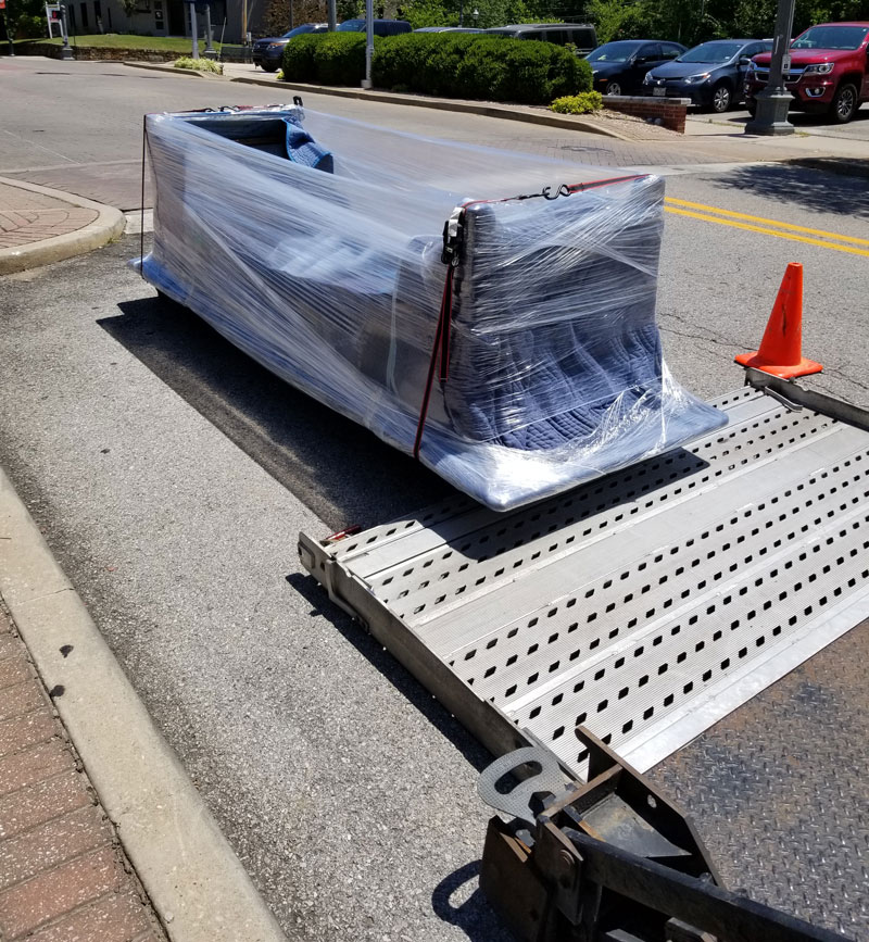 Blanket wrapped commercial machine rolled off or tailgate.